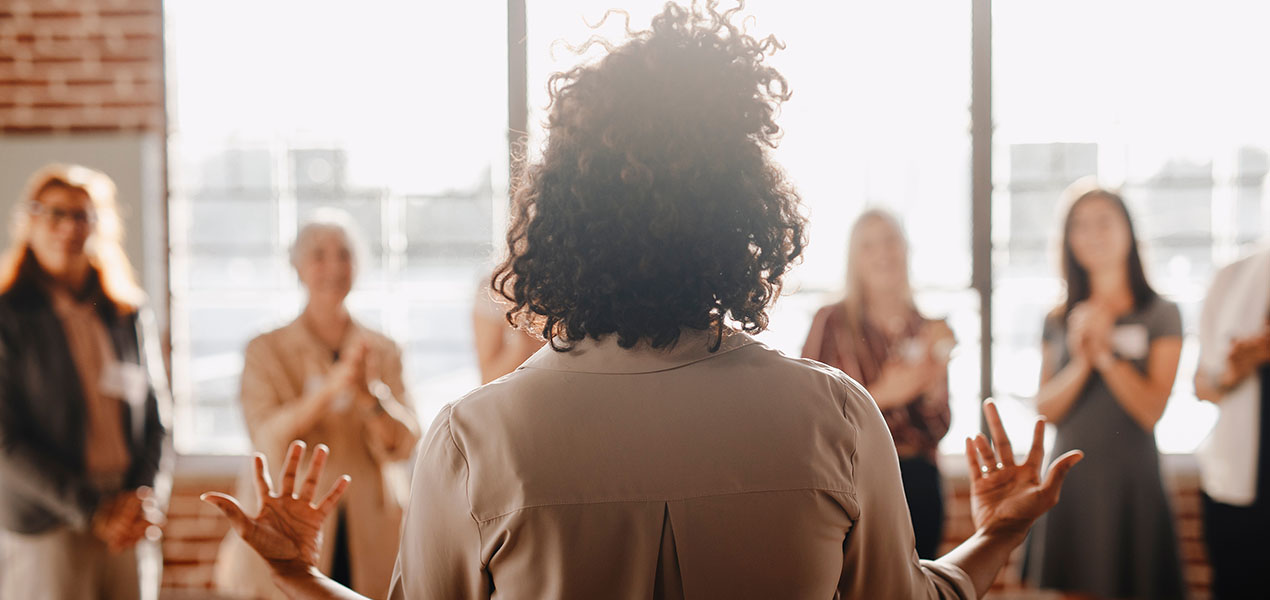 A group of women listen intently to a female speaker.