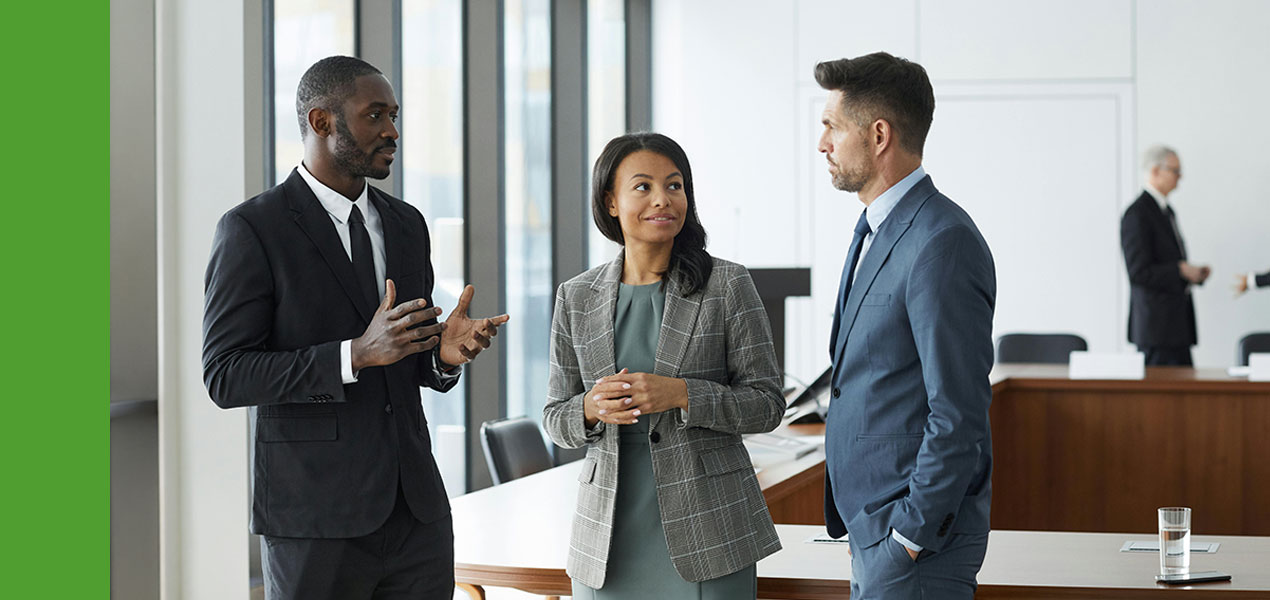 Three professionals engaged in discussion.