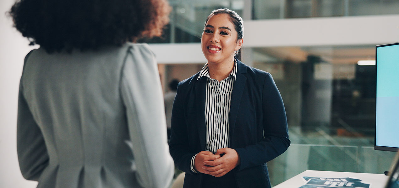A brand representative at a conference speaking with an attendee.