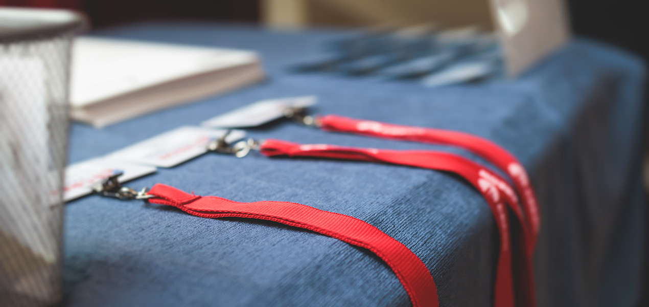 Three badges sitting on a conference welcome table.