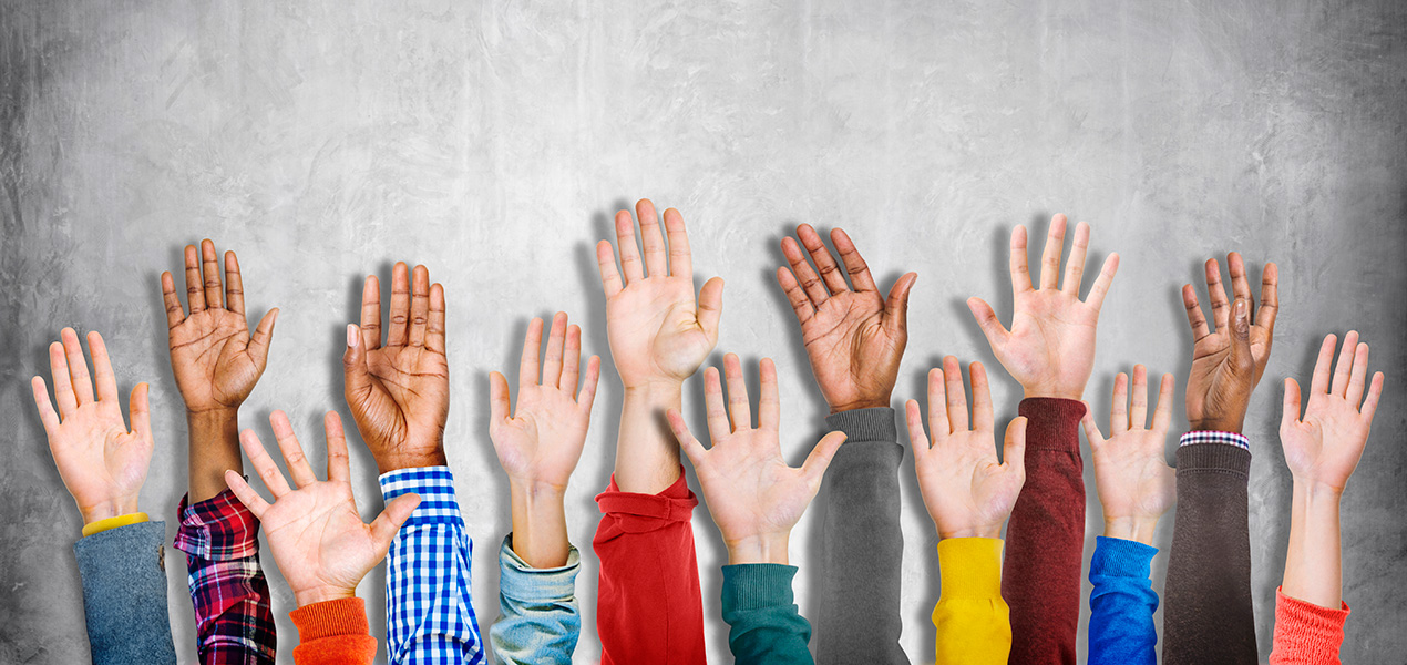 A diverse group of hands raised.