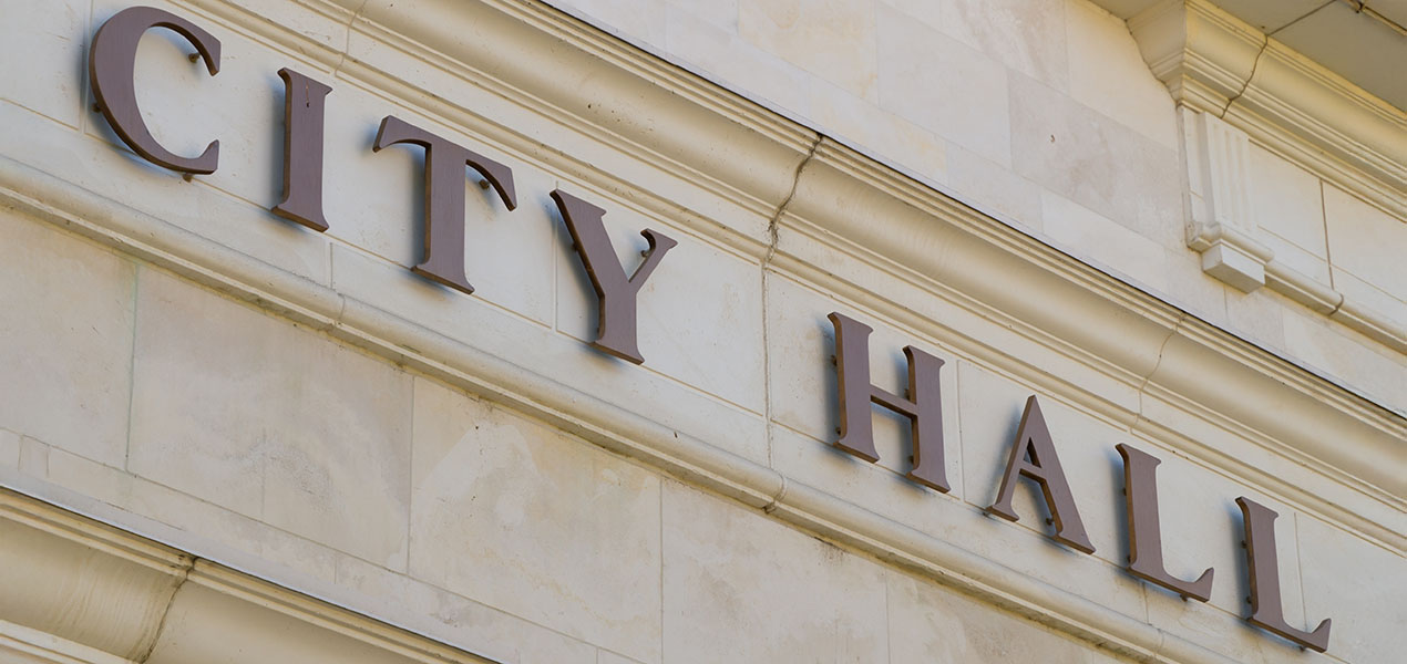An exterior view of a building letters spelling out "City Hall".