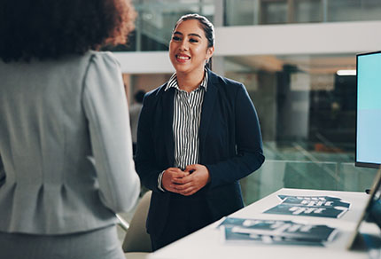 A brand representative at a conference speaking with an attendee.