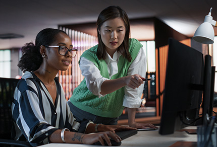 Mature woman wearing a headset, working on laptop.