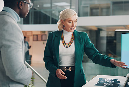 A brand representative at a conference speaking with an attendee.