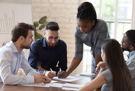 A diverse group of individuals collaborating on a project, sharing ideas and working together in a professional setting.