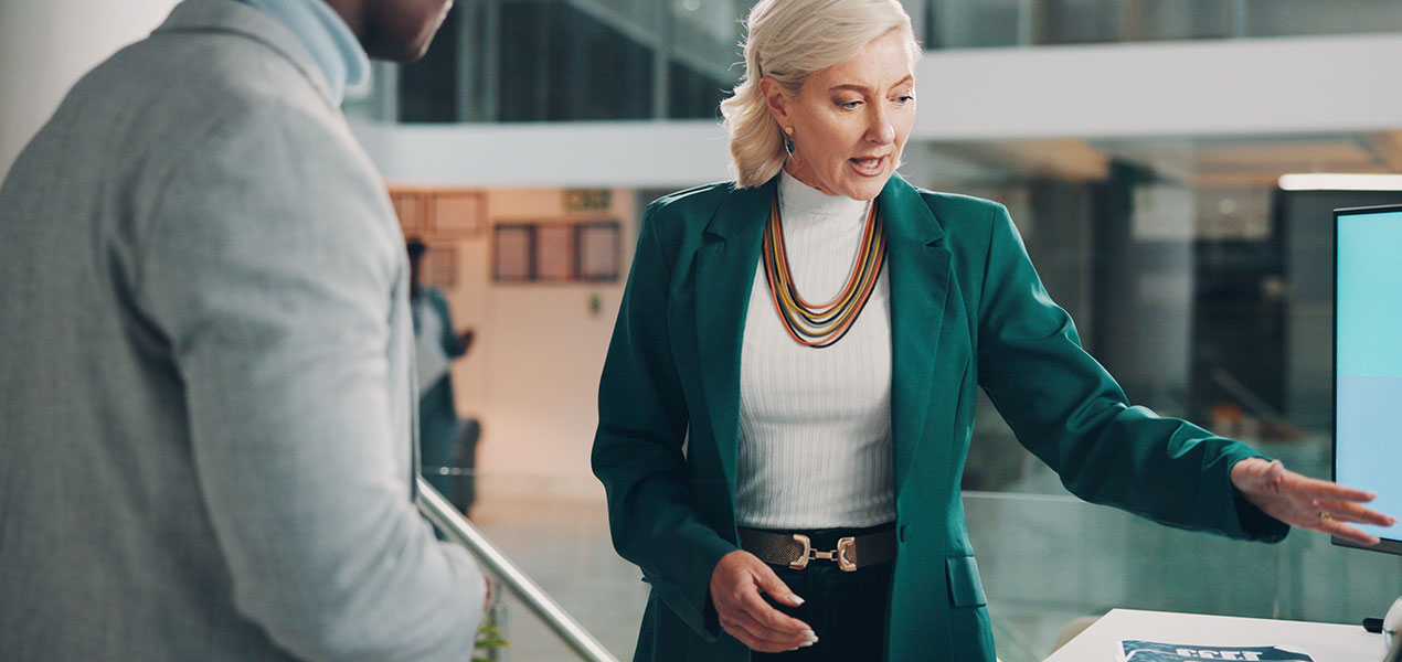 A brand representative at a conference speaking with an attendee.