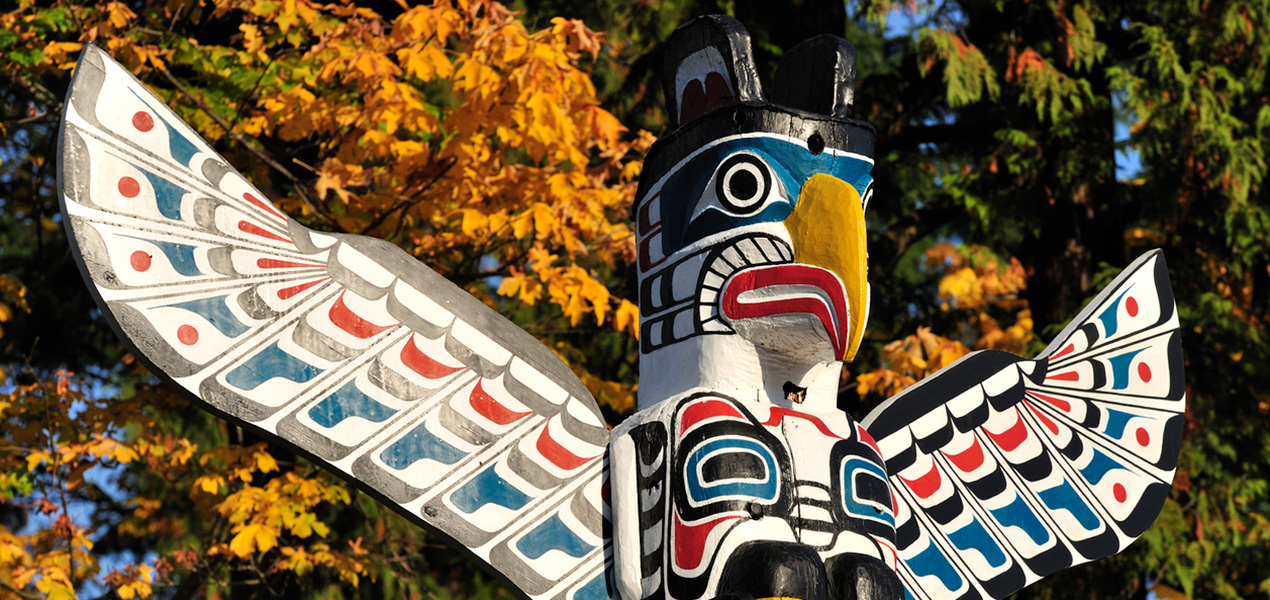 A brightly painted eagle at the top of a totem pole.